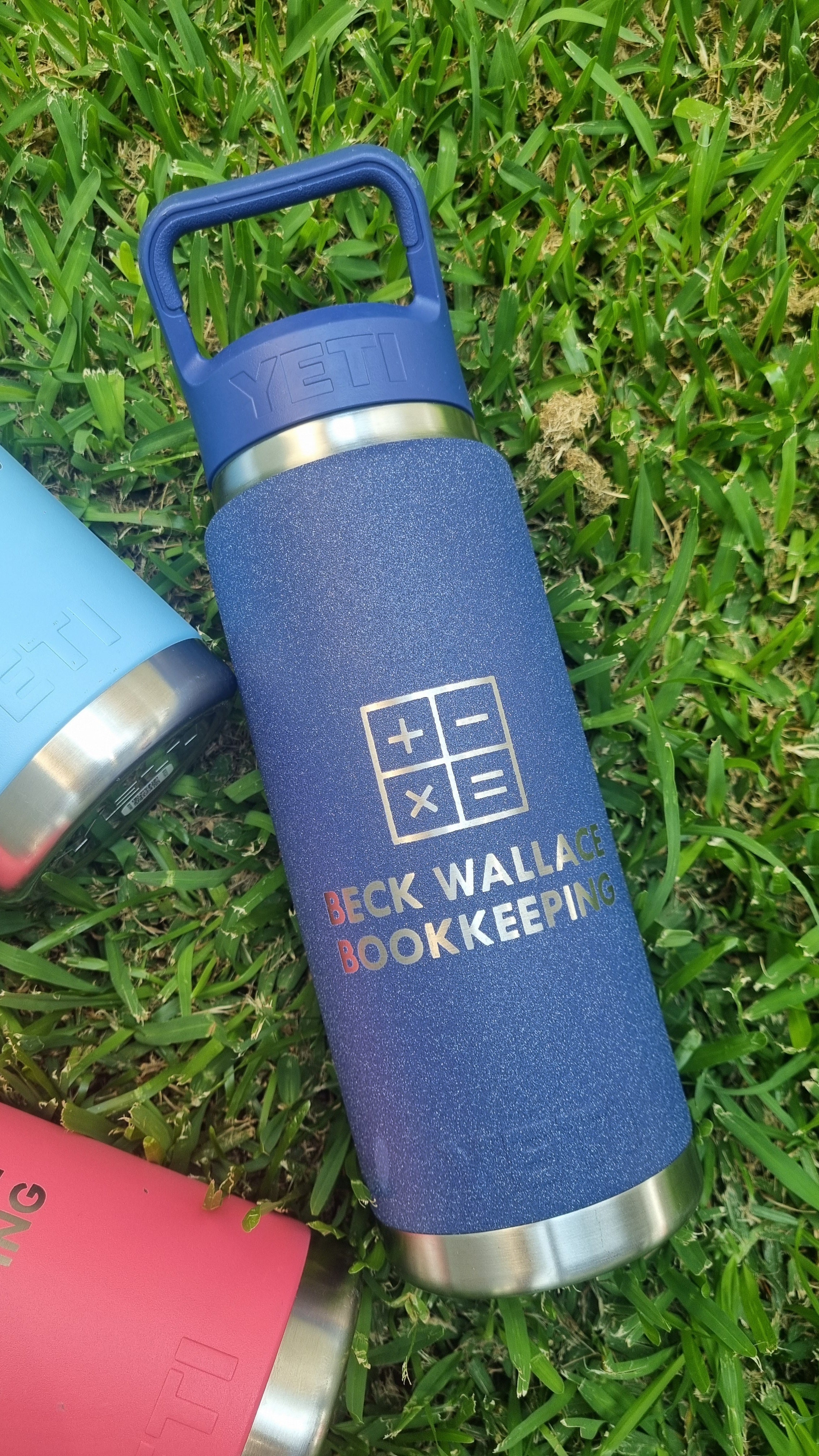 Blue water bottle with 'Beck Wallace Bookkeeping' branding on grass